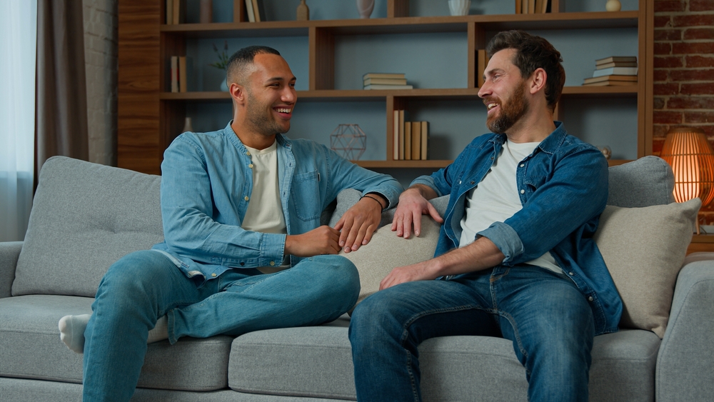 Two,Diverse,30s,Men,Businessmen,Talking,At,Home,On,Sofa